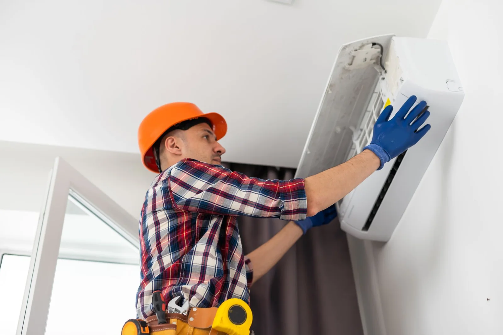 Technician working on a wall-mounted air conditioner